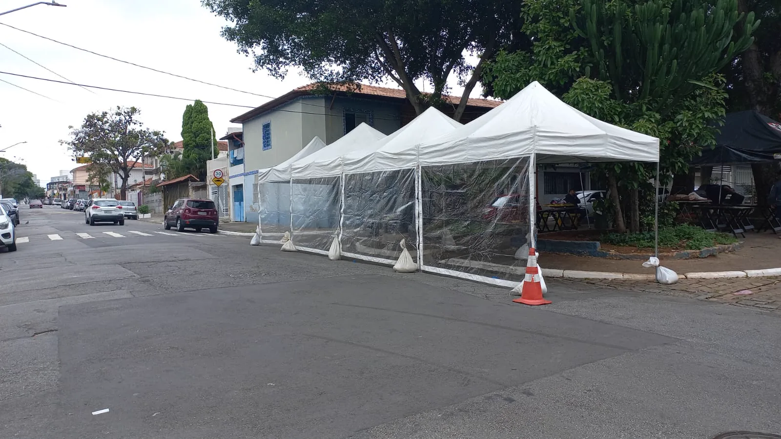 Avenida de feira organizada com várias tendas piramidais brancas