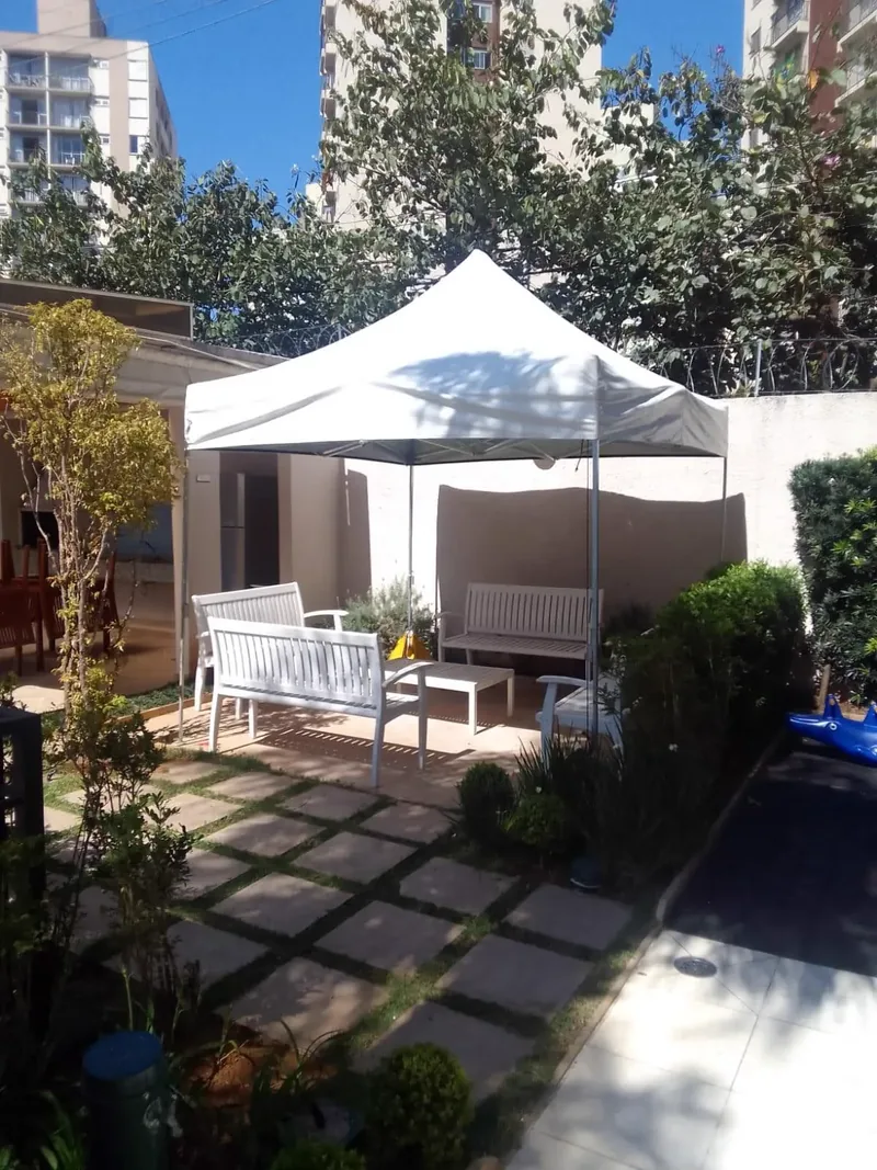 Tenda articulada branca com estrutura pantográfica aparente