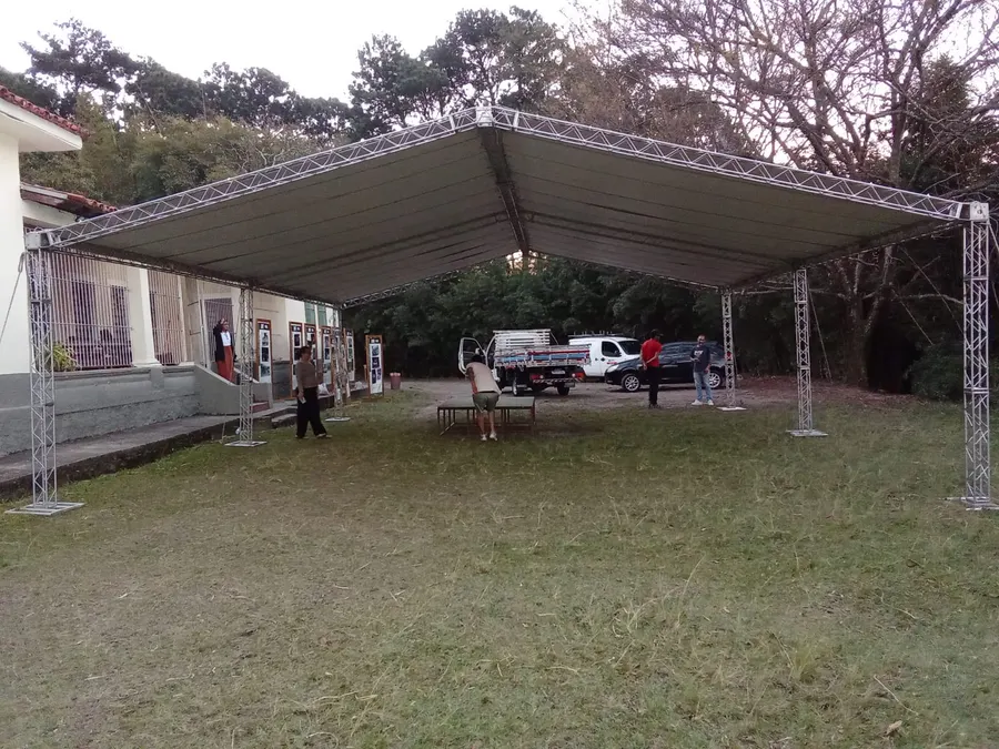 Tenda galpão 2 águas com estrutura de treliça montada sobre grama